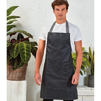 Κερωμένη ολόσωμη ποδιά τζιν PR134 DISTRICT με δερμάτινο λουρί, μεταλλικές οπές και τσέπη με εξώραφα.